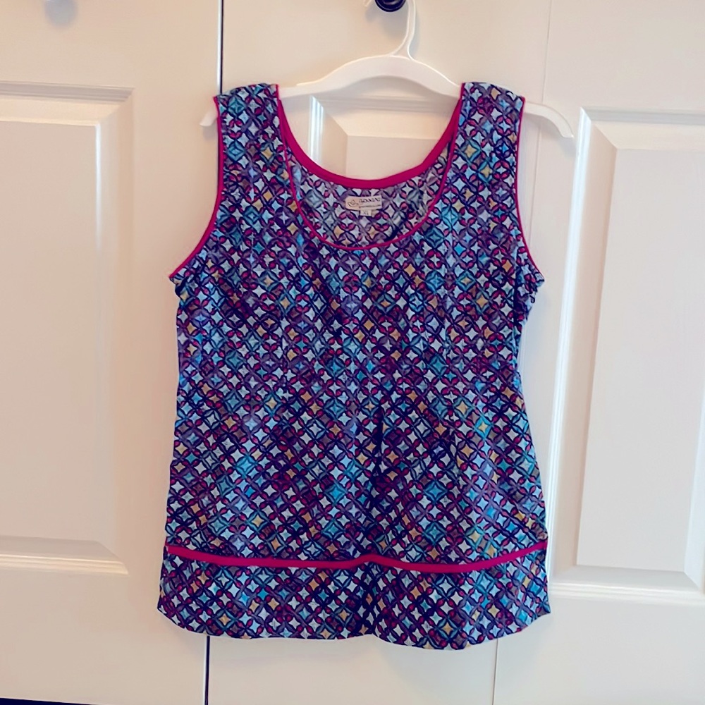 One of a kind woman’s top with multicolored star design and red piping.